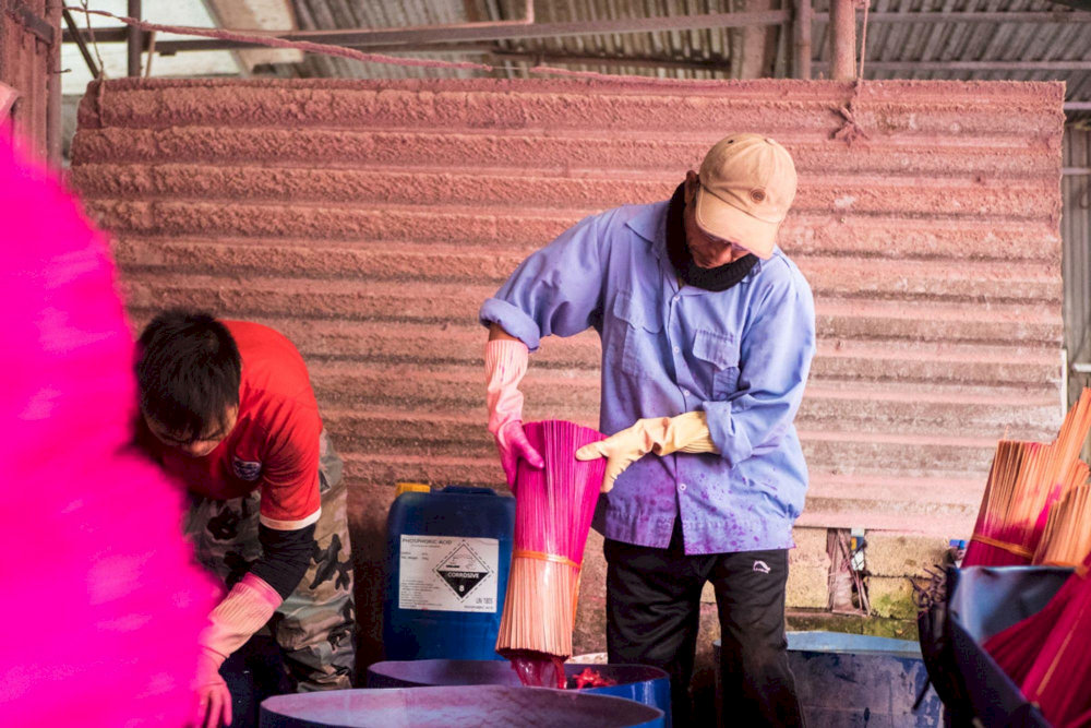 Artisans carefully dye incense sticks by hand